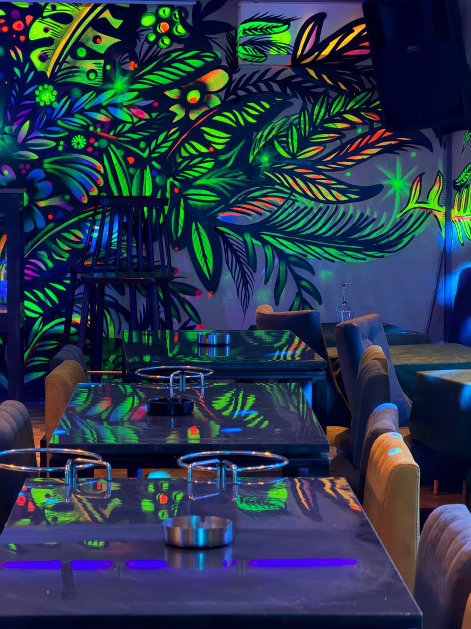 Fresque jungle fluo au-dessus des tables
